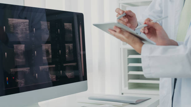 primer plano del equipo médico asiático médicos y doctoras médicos que verifican la imagen de rayos x del paciente en la computadora discutiendo el resultado de la reunión en el hospital. atención médica de salud. - x ray image radiologist examining using voice fotografías e imágenes de stock