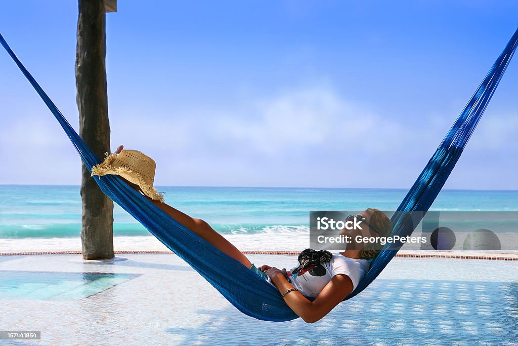 Kobieta relaks w basenie przelewowym z hamakiem - Zbiór zdjęć royalty-free (Hamak)