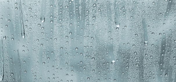 Close-up of water drops on silver surface, wet background