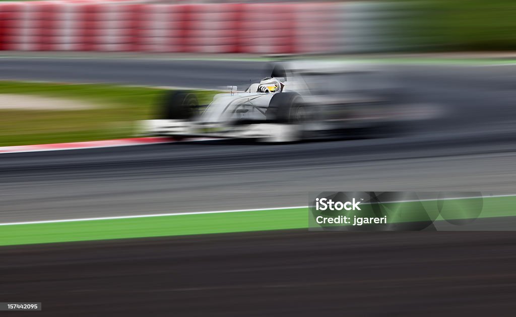An open-wheel race car in motion White, generic open-wheel race car during a practice run around a racetrack.  Can be colored any desired hue in Photoshop. Racecar Stock Photo