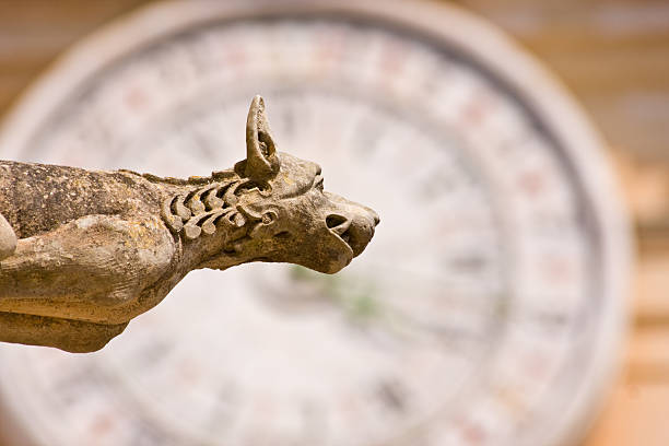 古代の石のガーゴイルアゲインスト時計の文字盤 - イムディーナ ストックフォトと画像