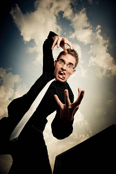 istock Gesturing and wildly grimacing young businessman sticking out tongue 157442374