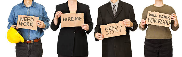 Unidentifiable men and women holding homemade cardboard job hunting signs, searching for work in an economic recession. The unemployed worker occupations include blue collar construction, white collar professional business careers, and manual labor. Handwritten text placards suggest concepts of recruitment, despair, working for food, dependency, and stress of employment issues.
