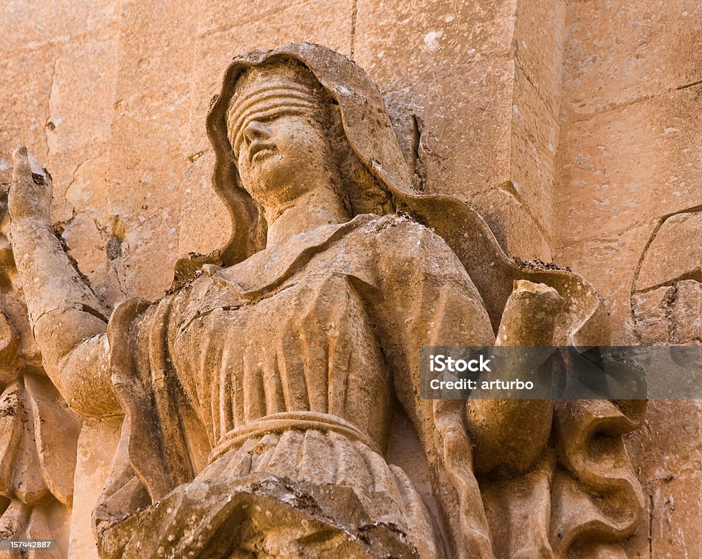 ancient sandstone Lady Justice medieval statue in the city of Mdina in Malta Law Stock Photo