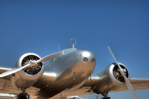 Silver WW2 plane against blue sky