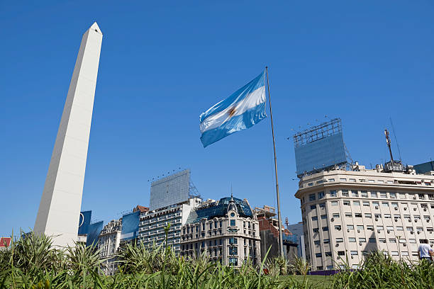argentina, buenos aires obelisco con bandiera dell'argentina - obelisco foto e immagini stock