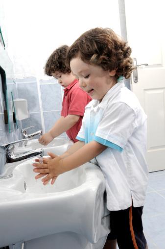 Kids washing hands in bathroom