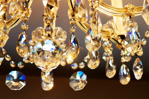 A closeup shot of a lighted chandelier hanging on the wall