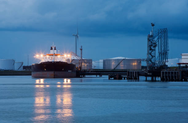 istock Super tanker at night with oil storage tanks 157443892