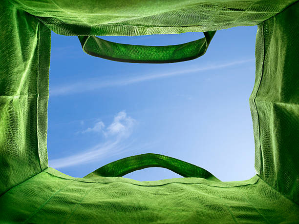 Bottom of a re-usable bag If one were sitting at the bottom of an empty bag and looked up... this would be the view. Looking out of an empty re-usable and recyclable grocery bag, with a view of a bright blue sky. reusable bag stock pictures, royalty-free photos & images