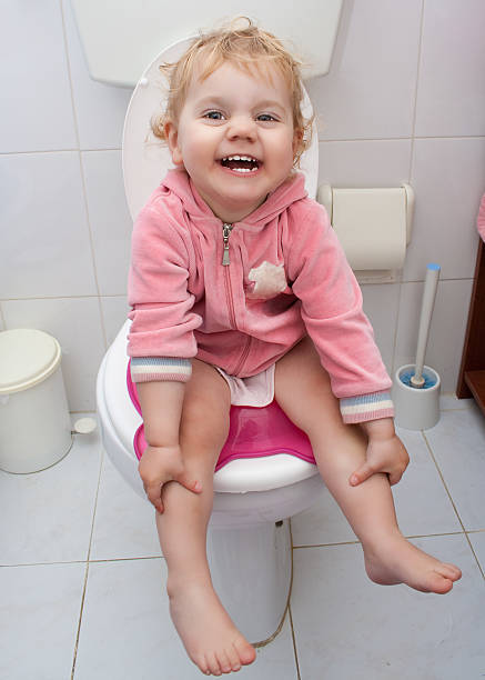 Baby girl sitting in the bath stock photo
