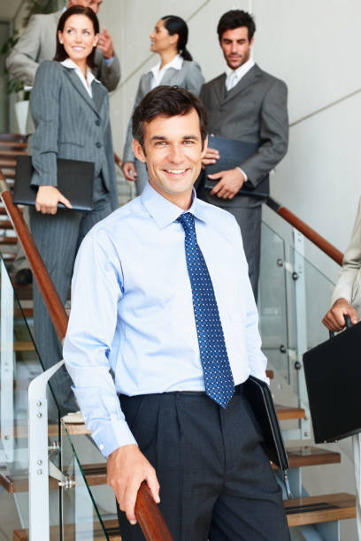 istock Confident businessman with colleagues in background 157444166