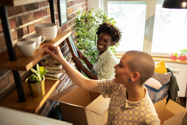 istock Young female couple unpacking and decorating their new apartment 1574445616
