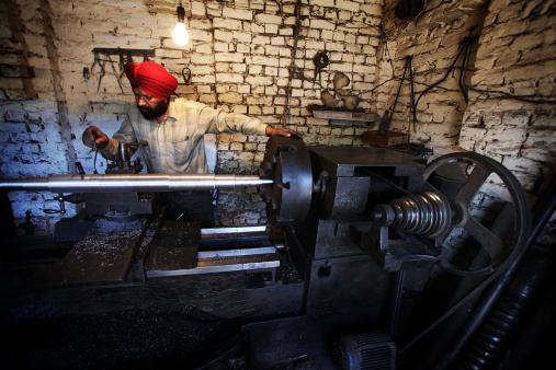 A Sikh lathe worker in his workshop.