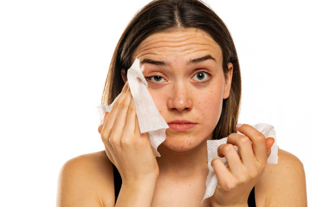 istock Young woman cleaning her face with wet wipe 1574474495