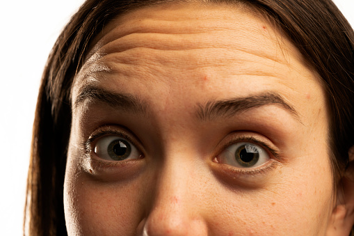 Portrait of a young woman looking at the camera outdoors, close up on face and shoulders