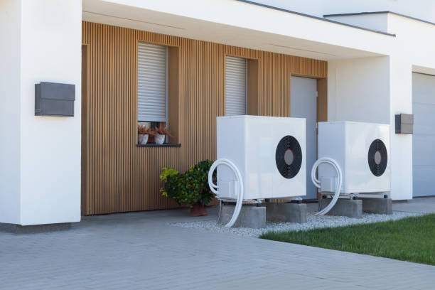 Eco-Friendly white Air Source Heat Pump at Moder New Home. A pair of air source heat pumps, an eco-friendly home heating solution, installed at a contemporary residential property. pump dress shoe stock pictures, royalty-free photos & images