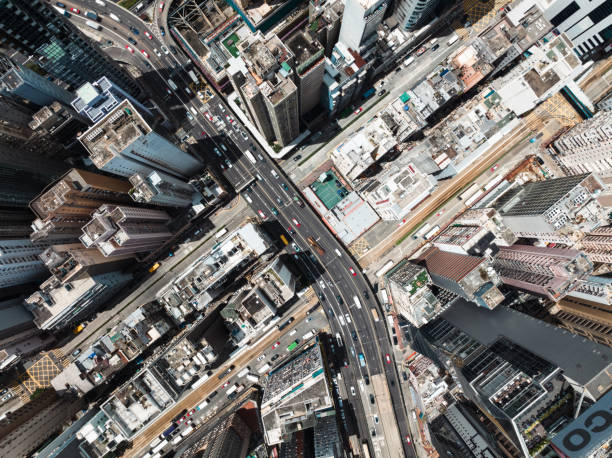 istock Car traffic transportation on highway road, skyscraper buildings, condominiums in financial business or residential district at Hong Kong island. Drone aerial cityscape top view. Asia transport travel 1574488359