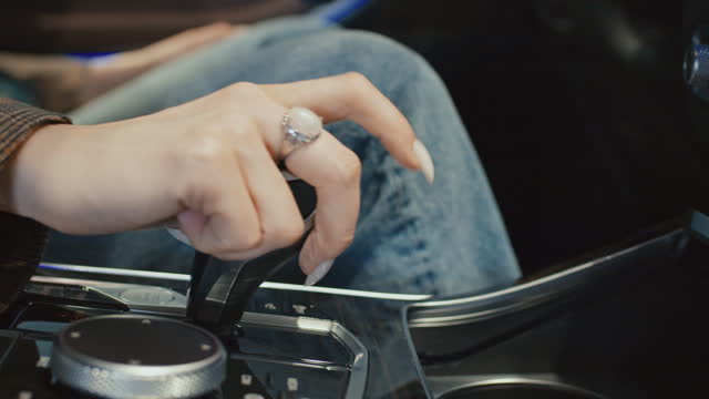 Hand of Anonymous Woman Trying Out Gear Transmission on New Car