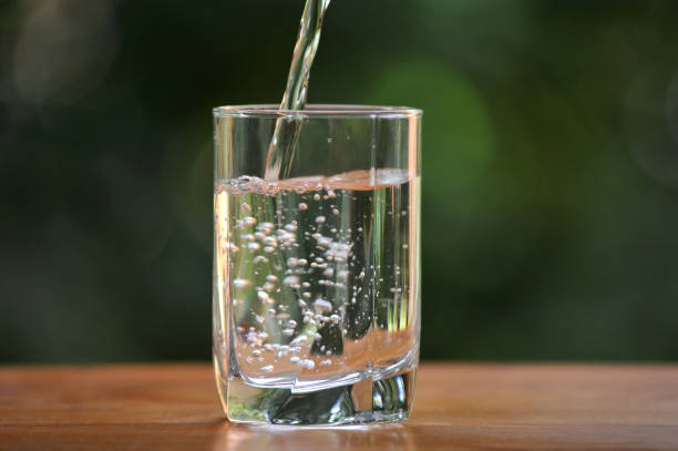 istock Pouring  fresh water into a glass 1574503764
