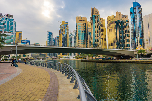 Dubai, UAE - December 5. 2019 - People go for a walk in an ultra modern city - Dubai Marina.
