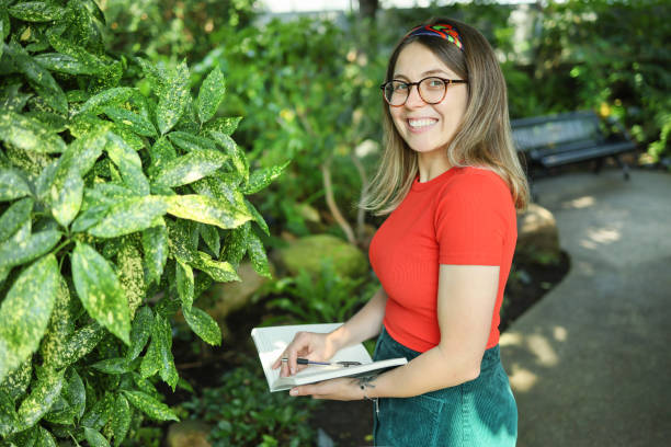 istock Young woman botanist take a notes in a botanical garden 1574518978