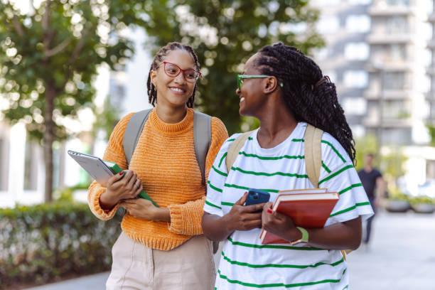 istock Female African American students cheerfully walking to class 1574544626