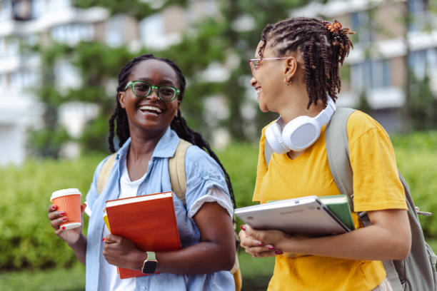 istock Two young, cheerful female students walking to class and having a conversation 1574555573