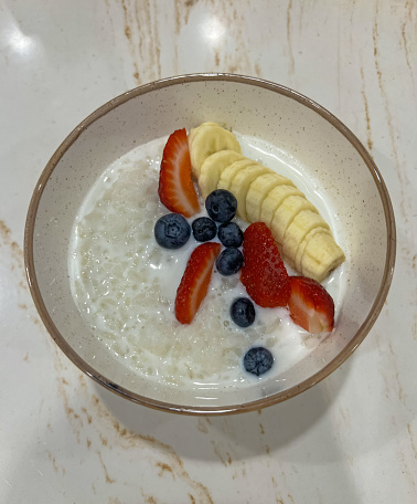 Rice porridge with banana, strawberry and blueberry. High quality photo