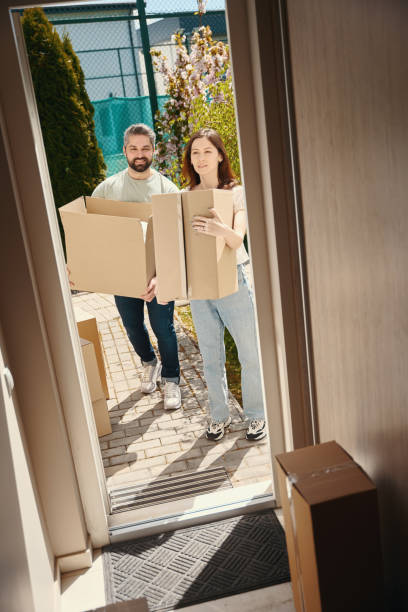 istock Couple in love bringing boxes into home 1574562017