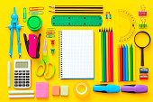 Multi colored school supplies shot on yellow background