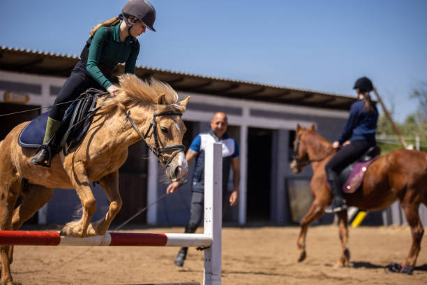 istock Girls training riding horses 1574593323