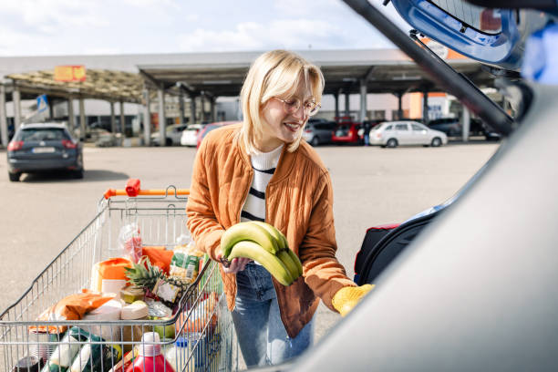 istock Young Caucasian woman unloading groceries 1574600319