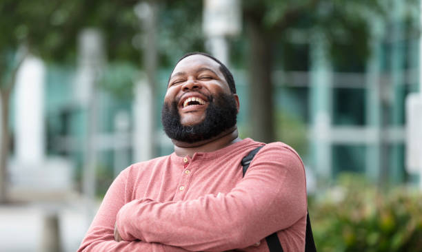 istock African-American man, laughing with arms folded 1574637258