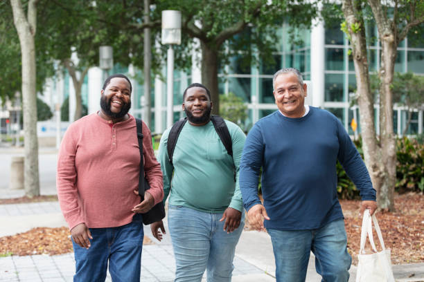 istock Three heavyset multiracial men walking on city sidewalk 1574637798