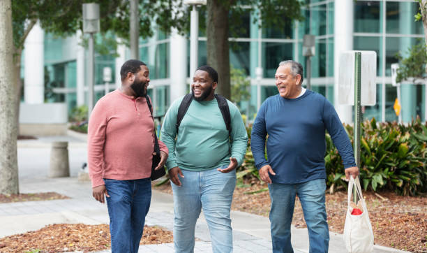 istock Three heavyset multiracial men walking on city sidewalk 1574637818