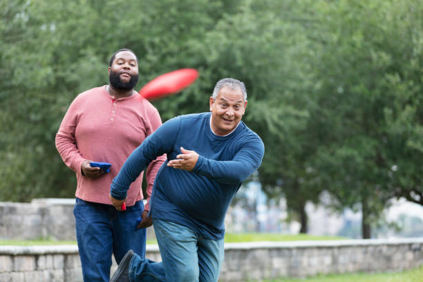 istock Two heavyset multiracial men playing bean bag toss 1574637845