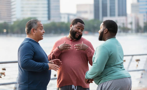 istock Three multiracial heavyset men talk on city waterfront 1574638909