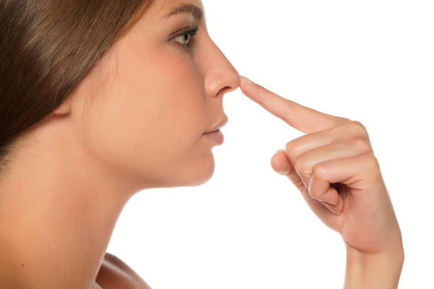 istock a young beautiful serious woman touches her nose 1574651625