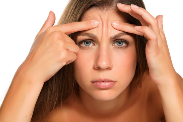 istock a young woman squeezes the wrinkles on her forehead 1574652634