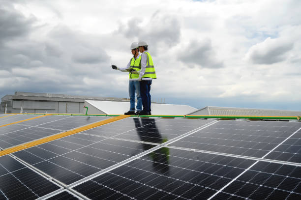 istock Young Engineers and Specialist Technicians  Discuss and Check Quality of Installing Solar Photovoltaic Panels and Use App Technology Checking Accumulated power generation from Solar Panel on Tablet. 1574676522