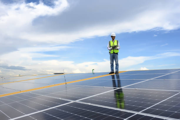 istock Engineer Inspector Quality in Solar Roof Panel Installation, Sustainable Photovoltaic Work for Factory Buildings. Natural Energy Sources Infrastructure Development in Efficiency. 1574676567