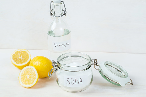 Baking soda in jar vinegar lemon on white background. The concept of removing stains on clothes