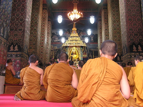 Several Buddhist monks seen worshipping during a ceremony in a temple in Thailand's Bangkok