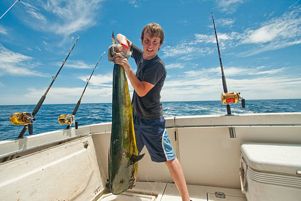 teen с mahimahi дорадо или дельфин рыба на лодке - image date one person happiness outdoors стоковые фото и изображения