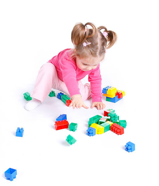 Dark girl climbing on toy stairs made of plastic blocks