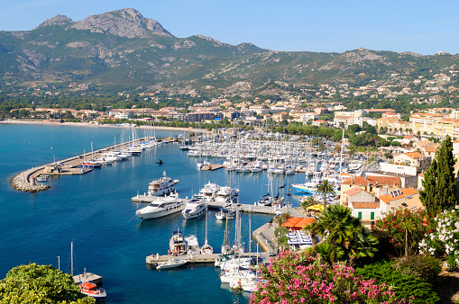 Aerial view of Mediterranean seascape of Roses town with yachts moored in harbor, Costa Brava, Spain