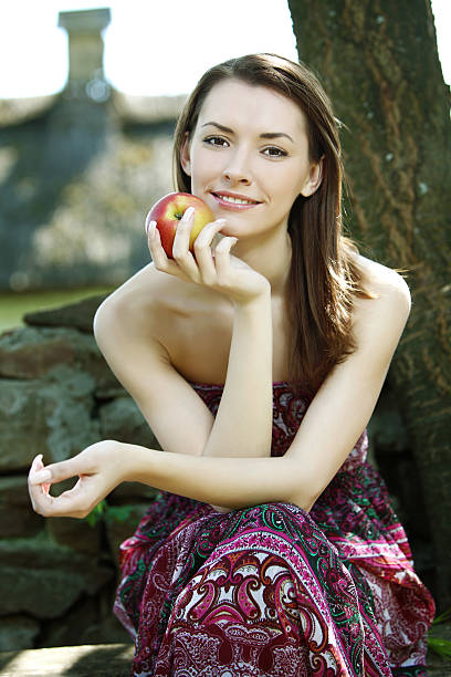 giovane donna con apple - bench sitting tree apple foto e immagini stock