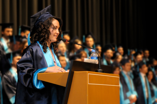 The most succesfull student of university is making a speech in her graduation ceremony. Shallow DOF.