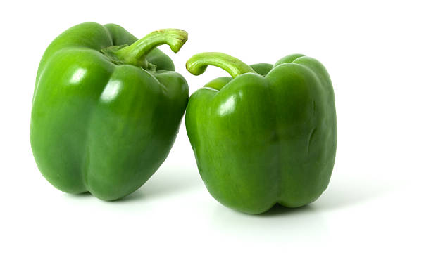 deux poivrons vert isolé sur fond blanc uni - green bell pepper photos et images de collection
